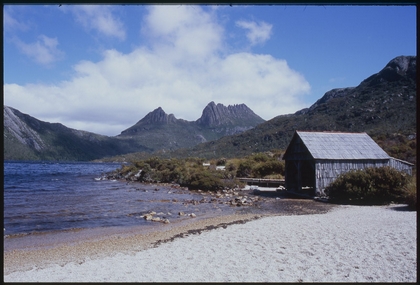 Hut near the edge of a lake with Cradle mountain in the background